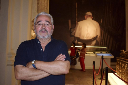 Alberto Cándido López, hijo del mesonero Cándido, con los cochinillos asados que han dado la vuelta al mundo, sobre las andas, y un retrato de su padre detrás, en el Mesón de Cándido de Segovia.-ARGICOMUNICACIÓN