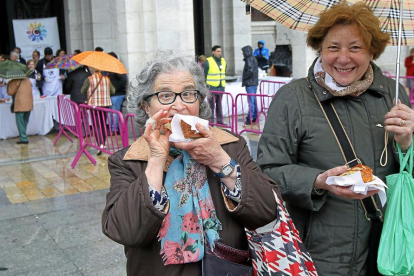 Dos mujeres con su porción de  la corona de San Pedro Regalado en la degustación celebrada ayer en la Plaza Mayor.-J. M. LOSTAU