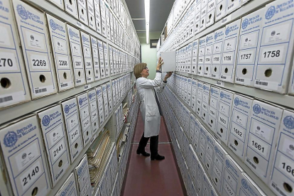 Una trabajadora sujeta uno de los archivos clasificados en las instalaciones del Archivo Provincial de la Diputación.-PABLO REQUEJO (PHOTOGENIC)