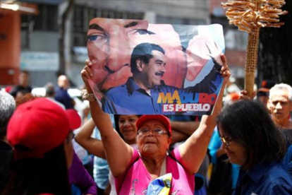 Una mujer, con una pancarta de apoyo a Maduro, el domingo, en Caracas-REUTERS / CHRISTIAN VERÓN