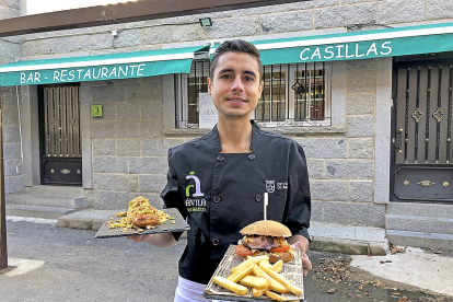 Diego Casillas, con dos de sus elaboraciones frente a la puerta de su restaurante en la localidad abulense de Navalacruz. / E. M.