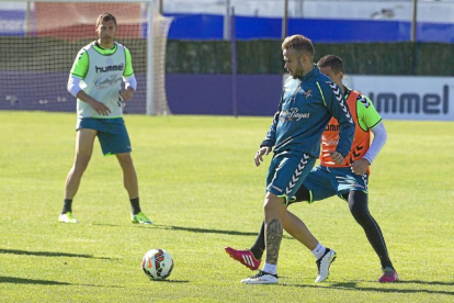 Roger da un pase durante el entrenamiento de ayer, ante la presión de Peña y la mirada de Samuel-P. REQUEJO