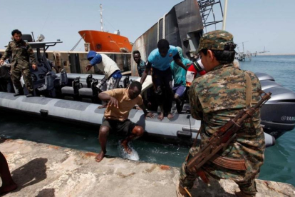 Inmigrantes llegan a la base naval libia después de haber sido rescatados por guardacostas libios en la costa de Trípoli.-REUTERS