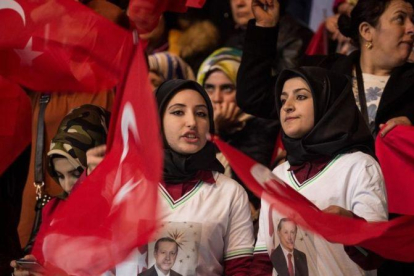 Dos mujeres con pañuelo y banderas turcas, en un mitin del partido gubernamental a favor del 'sí' en el próximo referéndum constitucional, en Ankara, el 25 de febrero.-GETTY IMAGES / CHRIS MCGRATH