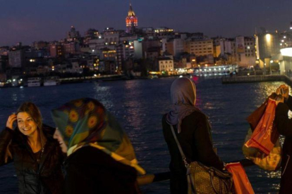 Varias mujeres con pañuelo y sin él fotografían el paisaje de Estambul desde el puente de Galata, el 23 de febrero.-GETTY IMAGES / CHRIS MCGRATH