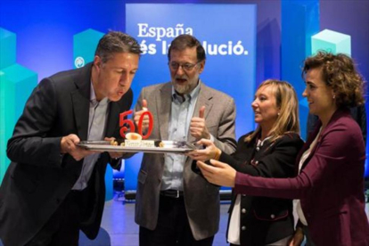 Garcia Albiol sopla las velas del pastel de su cumpleaños, en presencia de Mariano Rajoy, Marisa Xandri, líder del PP de Lleida, y Dolors Montserrat.-ACN