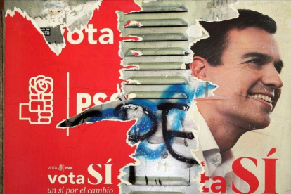 Uno de los carteles que los socialistas utilizaron en campaña electoral, ahora deteriorado, con la imagen de Pedro Sánchez.-REUTERS
