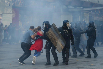 Manifestantes huyen del gas lacrimógeno, en la manifestación de los ’chalecos amarillos’ en París. / LUCAS BARIOULET / AFP-AFP / LUCAS BARIOULET