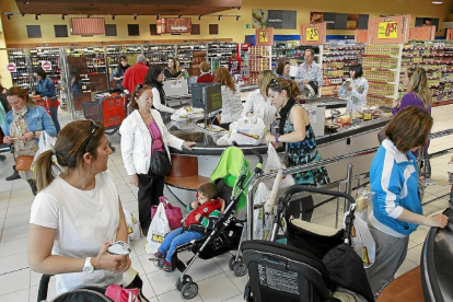 Varias personas realizan sus compras en un supermercado.-J.M. LOSTAU