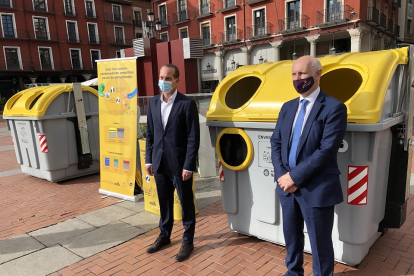 Ángel Hervella, de Ecoembes (izquierda), y Alberto Palomino (derecha) posan delante de los nuevos contenedores amarillos que se instalarán en la ciudad.- E. PRESS