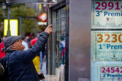 Un hombre señala el décimo de Lotería de Navidad que quiere comprar en una Administración en la plaza de Puerta del Sol, en Madrid (España), a 18 de noviembre de 2019.-EUROPA PRESS