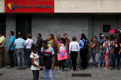 Ciudadanos venezolanos hacen cola en una cajero automático en una sucursal bancaria en Caracas, el viernes.-REUTERS / NACHO DOCE