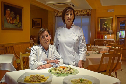 Las hermanas Josefina y Araceli, en el comedor del restaurante familiar de Salas de los Infantes, con algunos platos representativos de la casa.-ARGICOMUNICACIÓN