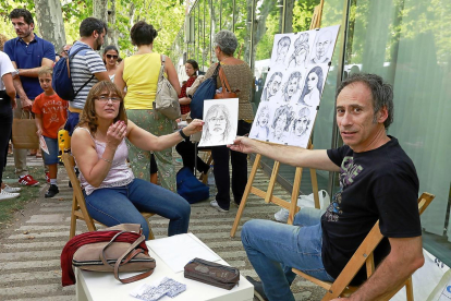 María Barrio enseña el dibujo que le ha hecho el pintor Julio Sendino en Recoletos.-J. M. LOSTAU