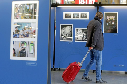 Un viajero contempla una de las fotografías de la exposición en la estación de Campo Grande.-J.M. LOSTAU