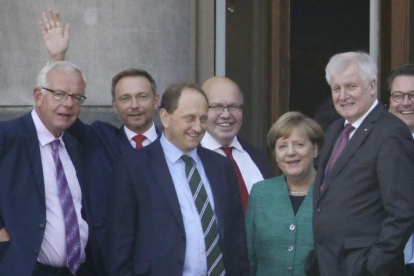 Angela Merkel este miércoles en Berlín con dirigentes de los partidos políticos con los que está negociando un posible gobierno de coalición.-AP / MICHAEL KAPPELER