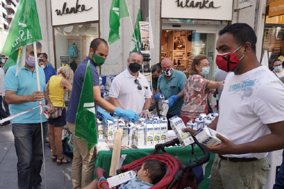 Un momento de la entrega de leche gratis por parte de las organizaciones agrarias en la calle Santiago de Valladolid. ICAL