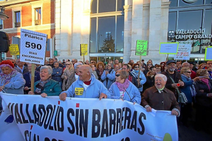 Los manifestantes de Pilarica portan la pancarta y carteles para recordar los 590 días desde que se cerró el paso a nivel.-ICAL