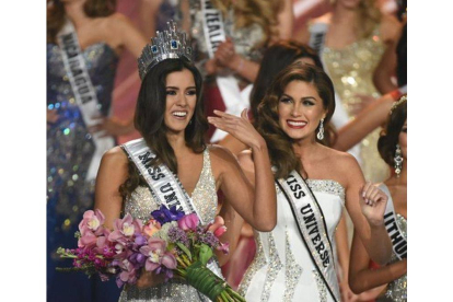 Miss Colombia recibe la corona de Miss Universo que le coloca la vencedora del año pasado, la venezolana Gabriela Isler.-Foto: AFP