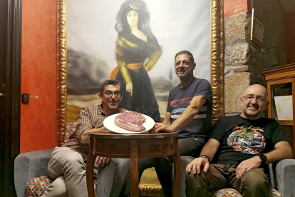Julio, Antonio y Suso, frente a un retrato de Cayetana de Alba, en su restaurante de Piedrahíta.