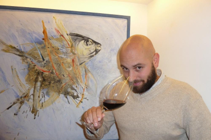 Rubén Arnaz cata uno de los vinos de la carta del establecimiento junto a un óleo del artista segoviano Luis Moro, homenaje a los pescados del mar de Castilla.-T.ST.