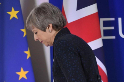 La primera ministra británica, Theresa May, pasa ante las banderas de la UE y del Reino Unido tras celebrar una rueda de prensa en Bruselas.-EMMANUEL DUNAND (AFP)