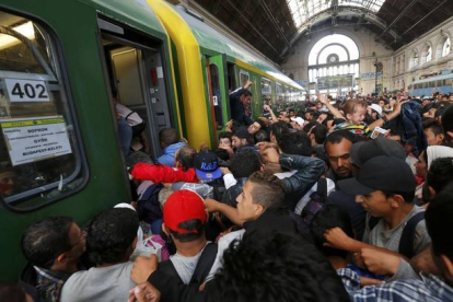 Los cientos de inmigrantes que han esperado durante dos días la reapertura de la estación de Keleti suben masivamente al primer tren.-REUTERS