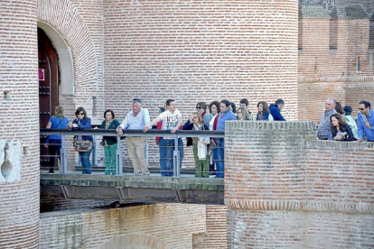 Un grupo de turistas, acompañados por un guía, se asoma a la pasarela del Castillo de La Mota, para observar el foso-SANTIAGO G. DEL CAMPO