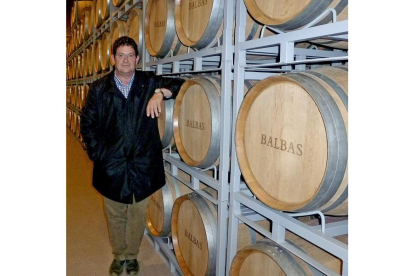 Juan Jose Balbás posa junto a unas barricas de su bodega, donde reposa el vino.-E.M.