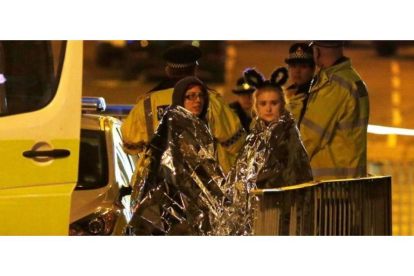 Dos chicas son atendidas por los servicios de emergencia a las afueras del Manchester Arena.-REUTERS