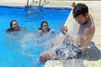 Tres jóvenes se divierten y se refrescan en una piscina privada para hacer frente al calor en Valladolid.-J. M. Lostau