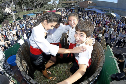 Cuatro jóvenes de la localidad realizan el tradicional pisado de la uva dentro de la barrica durante la jornada de ayer.-J.M. LOSTAU