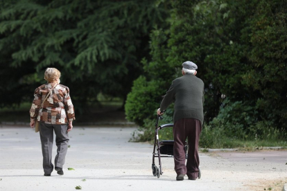Una mujer y un hombre de edad avanzada pasen por la calle.- E. PRESS