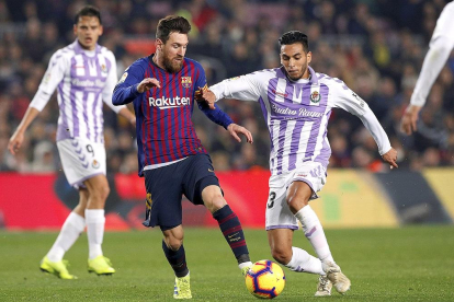 El blanquivioleta Anuar impide el control de balón del azulgrana Messi, ante la mirada de Ünal.-ALBERT GEA / REUTERS