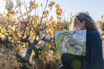 Ana Casis, en su viña, con el cuadro que se representa en la etiqueta de su nuevo vino, Los Turuntales Autor, elaborado con uva negro saurí. / ÁNGEL MORENO.
