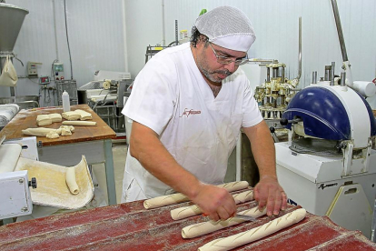 Bizien Serrano da forma a las barras fabiola en el obrador de la panadería San Francisco de Palencia.-BRÁGIMO