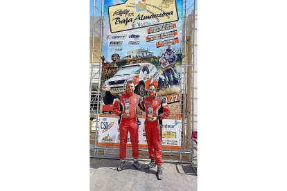 Jorge Pulido y Carlos González posan junto al cartel de la anterior prueba disputada, el  Baja Almanzora.-EL MUNDO