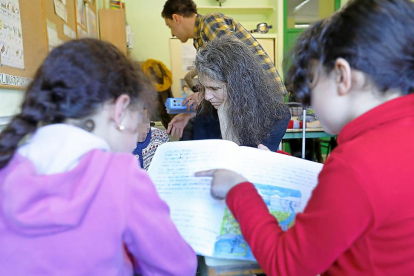 Isabel y Rodrigo, de Azacán, ayudan a varios alumnos de Primaria en una clase de apoyo extraescolar para niños inmigrantes en el Pablo Picasso.-J.M.LOSTAU