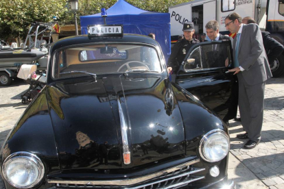 El director general de la Policía, Ignacio Cosidó (C) observa un antiguo coche de la policía, junto al alcalde, Alfonso Polanco; en su visita a una muestra sobre vehículos y material utilizados por la Policía-Ical