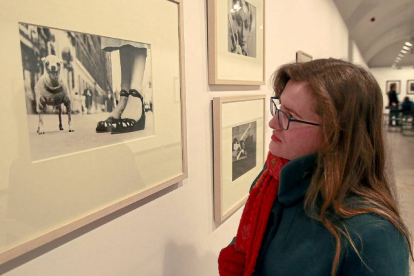 Una mujer observa las imágenes de la exposición de fotografías de Lola Garrido-J.M.Lostau