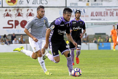 Jose se lleva el balón tras eludir el marcaje de un jugador del Oviedo en el partido disputado en Luarca.-ARABA PRESS