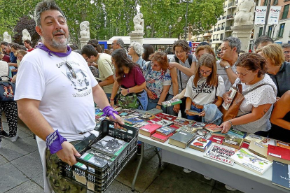 Un integrante de la peña Los Comuneros coloca los libros donados en unas mesas en la plaza de la Universidad.-REPORTAJE GRÁFICO: J. M. LOSTAU