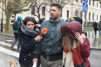 Víctor Rodríguez se aleja del Palacio de Justicia de Burgos junto a su novia perseguido por una redactora de televisión.-ICAL