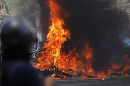 Varios vehículos en llamas tras enfrentamientos entre manifestantes y policías en Venezuela.-CARLOS GARCIA RAWLINS / REUTERS