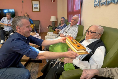 Sergio Palacios sopla la tarta con la vela de los 107 años ante la presencia de su sobrino Julio.-PABLO REQUEJO