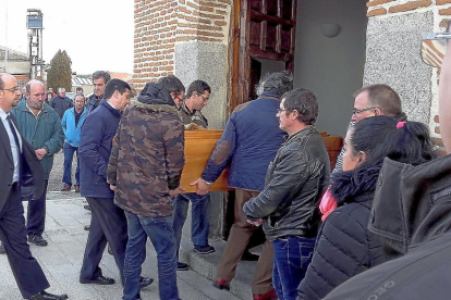 Familiares y amigos introducen el féretro del joven José Manuel Gutiérrez en la iglesia de Hornillos de Eresma, momentos antes del funeral celebrado ayer.-S. G. C.