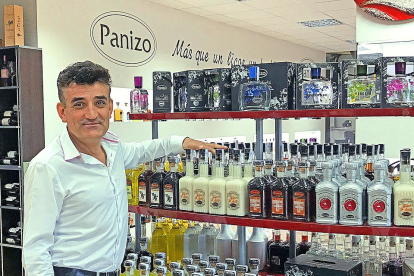 Jerónimo Panizo posa frente a sus productos en la tienda de la fábrica de Orujos Panizo./ ARGICOMUNICACIÓN.