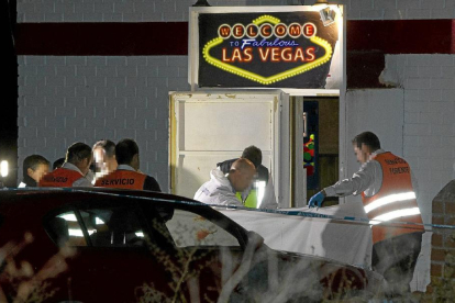 Agentes de la Policía científica cubren el cadáver de Mariano Esteban en el exterior del local, el pasado año.-J. M. Lostau