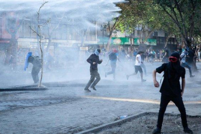 La policía lanza cañones de agua para dispersar a los manifestantes, el pasado sábado en Santiago.-PAULA ACUNZO (DPA)
