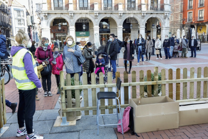 Varias personas forman cola respetando las medidas de seguridad en la Plaza Mayor para entrar al tren navideño. REPORTAJE GRÁFICO:J.M. LOSTAU